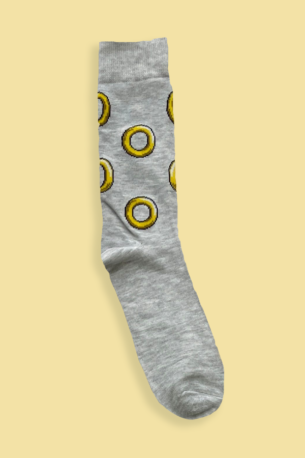 Gray sock with yellow donut pattern on a beige background
