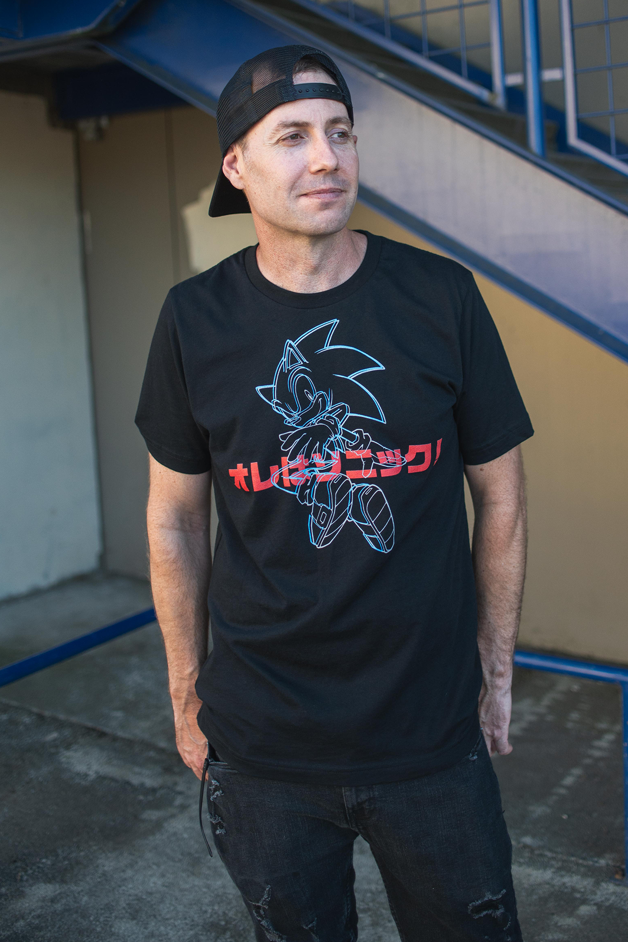 Man wearing a black t-shirt with a graphic design outdoors